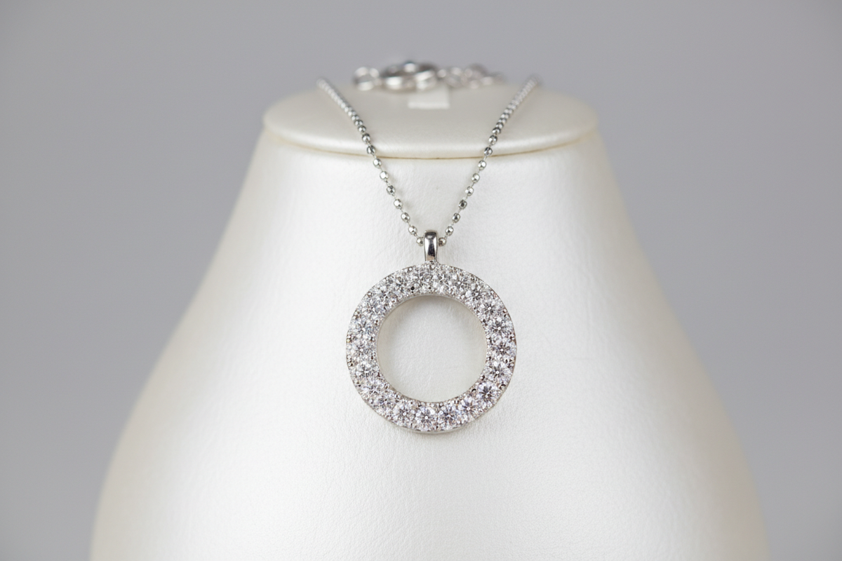 A mid-luxury diamond necklace featuring a circular motif encrusted with pavé diamonds, blending symbolic form (circle = eternity) with sparkle. Great entry-level luxury statement piece.